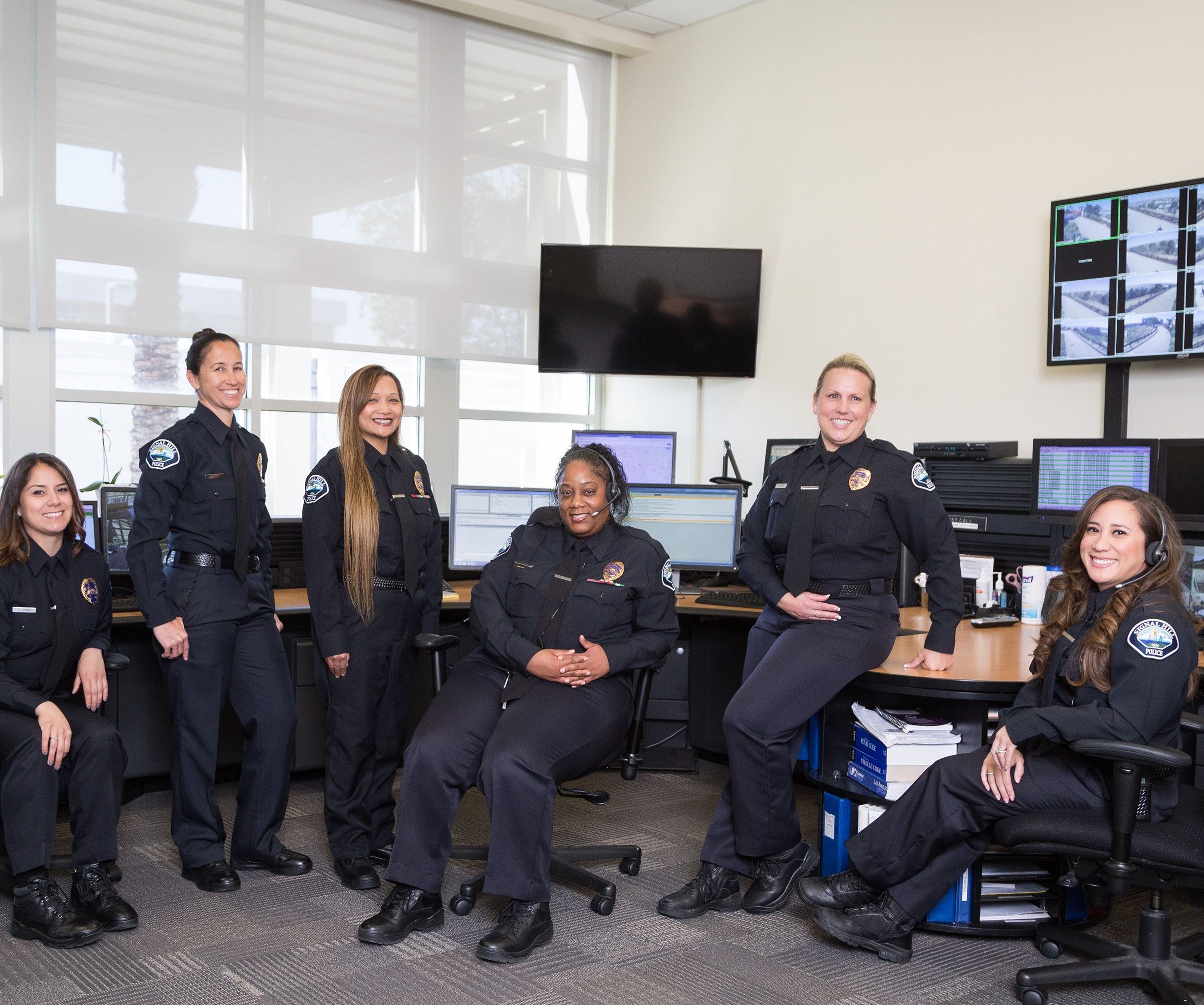 Dispatchers smiling in front of dispatch center