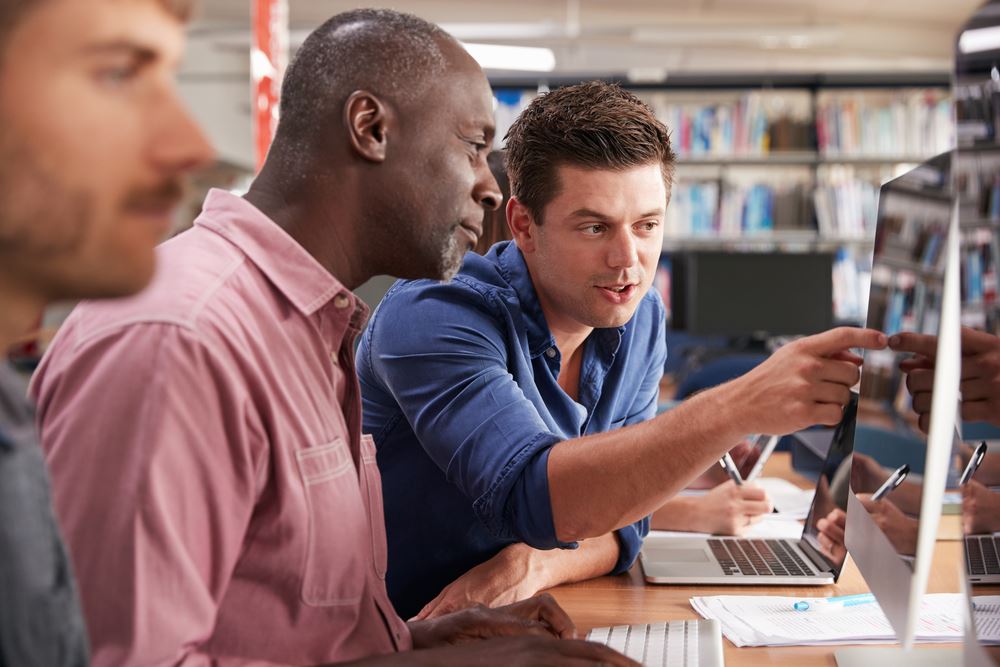 Tutor showing an adult student something on a computer